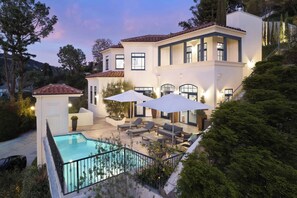 A large house with a swimming pool, outdoor seating, and a well-lit patio area. - Chateau Beverly Hills by Stay Awhile Villas (Beverly Hills)
