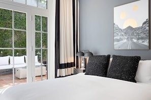Ein Schlafzimmer mit einem großen Bett, einem Nachttisch, einer Lampe und einem Gemälde an der Wand.