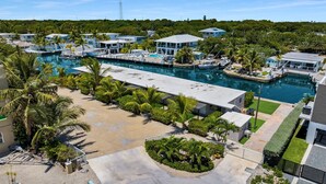 A marina with boats, a swimming pool, and a resort area with palm trees. - 6. Key Largo Waterfront Studio / Dock / Snorkel (Key Largo)