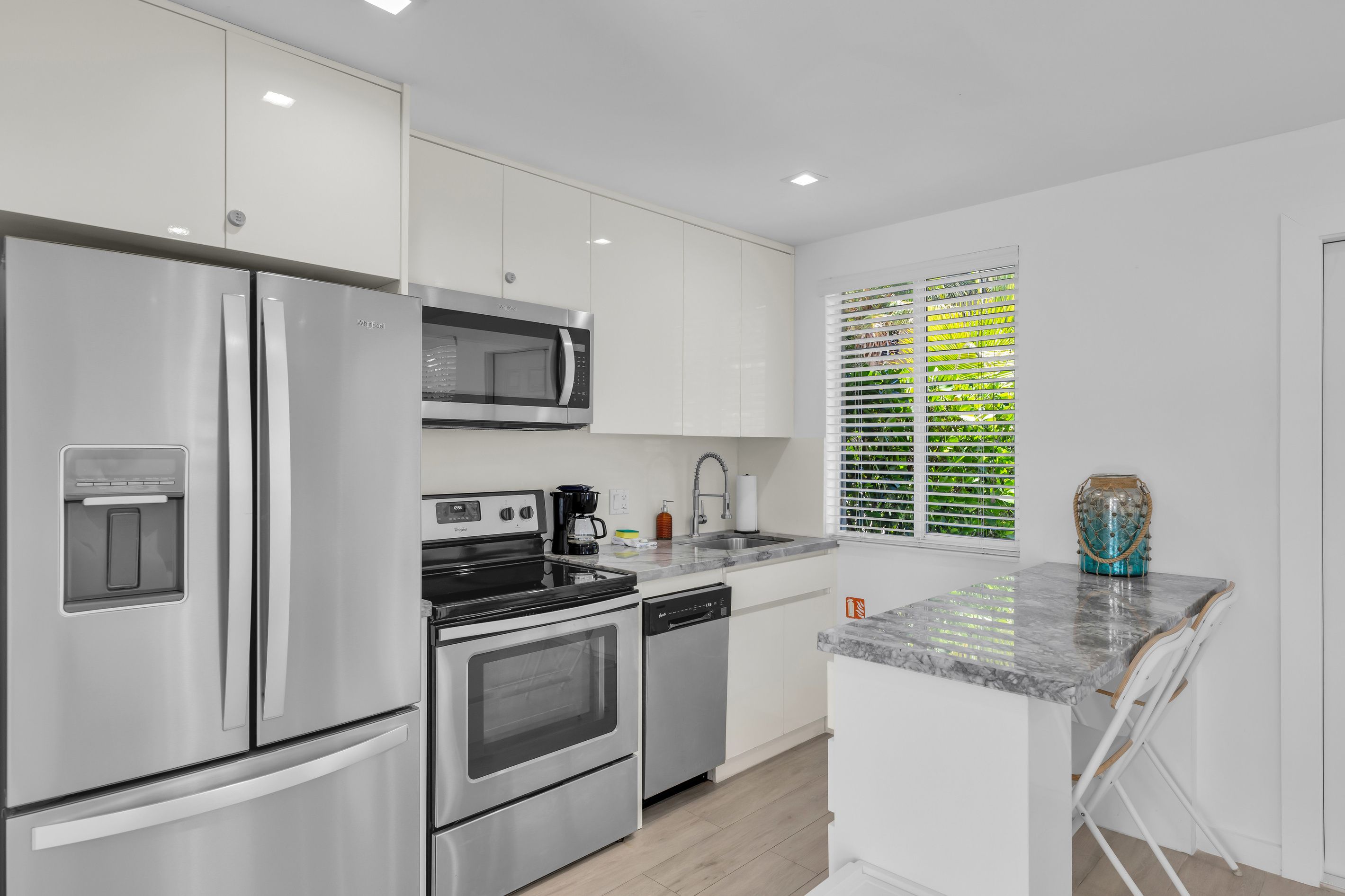 A modern kitchen with stainless steel appliances, a built-in oven, and a coffee maker.