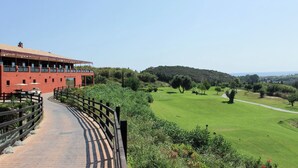 Un edificio rojo con un sendero pavimentado que lleva a un campo verde.