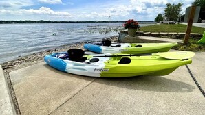 Two kayaks on a concrete dock by a lake with a clear sky. - Quaint 2 bedroom cottage at Bass Lake-paddle boards, kayaks, private ramp, bikes (Knox)