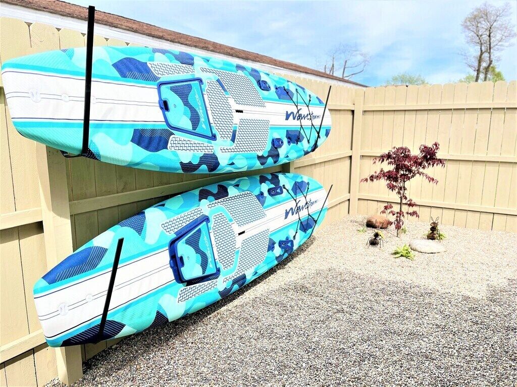 Two surfboards leaning against a wooden fence.