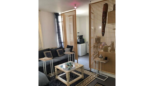 A modern living room with a sofa, coffee table, and decorative screens.