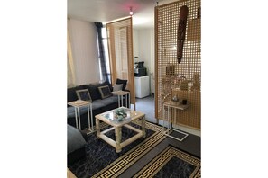 A modern living room with a sofa, coffee table, and decorative screens. - COSY T2 Marseille (Marseille)