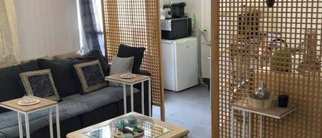 Un salon moderne avec un canapé, une table basse et des paravents décoratifs.