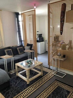 Ein modernes Wohnzimmer mit einer Couch, einem Couchtisch und dekorativen Paravents.