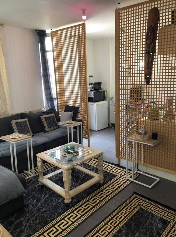 A modern living room with a sofa, coffee table, and decorative screens.
