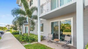 A modern building with a balcony, outdoor seating, and a clear view of the surrounding area. - Stylish & Cozy ~ 15mins to Downtown & Beach ~ Pool (West Palm Beach)