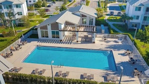 A large rectangular swimming pool with lounge chairs and a covered patio area. - Stylish & Cozy ~ 15mins to Downtown & Beach ~ Pool (West Palm Beach)