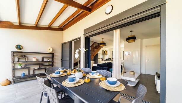 A dining area with a long table set for four, surrounded by chairs. - Villa Nueva-Tourist accommodation 3*-Private pool (Saint-Pierre)