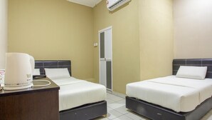 A hotel room with two beds, a desk with a coffee maker, and an air conditioning unit. - Lodge 37T (Ranau)
