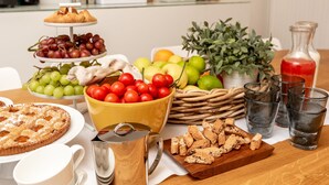 A breakfast buffet with various fruits, pastries, and beverages. - COLONNA24 (Portovenere)