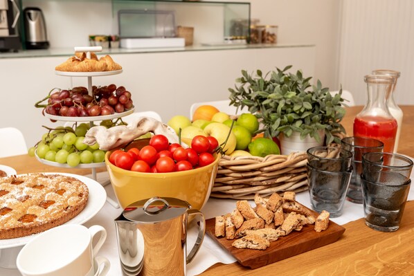 A breakfast buffet with various fruits, pastries, and beverages. - COLONNA24 (Portovenere)