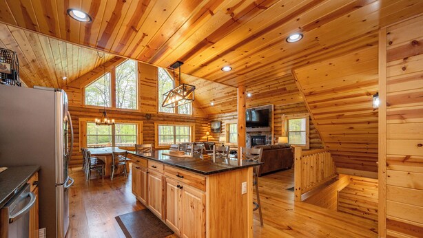Ein Holzblockhaus mit Küche, Essbereich und Wohnbereich.
