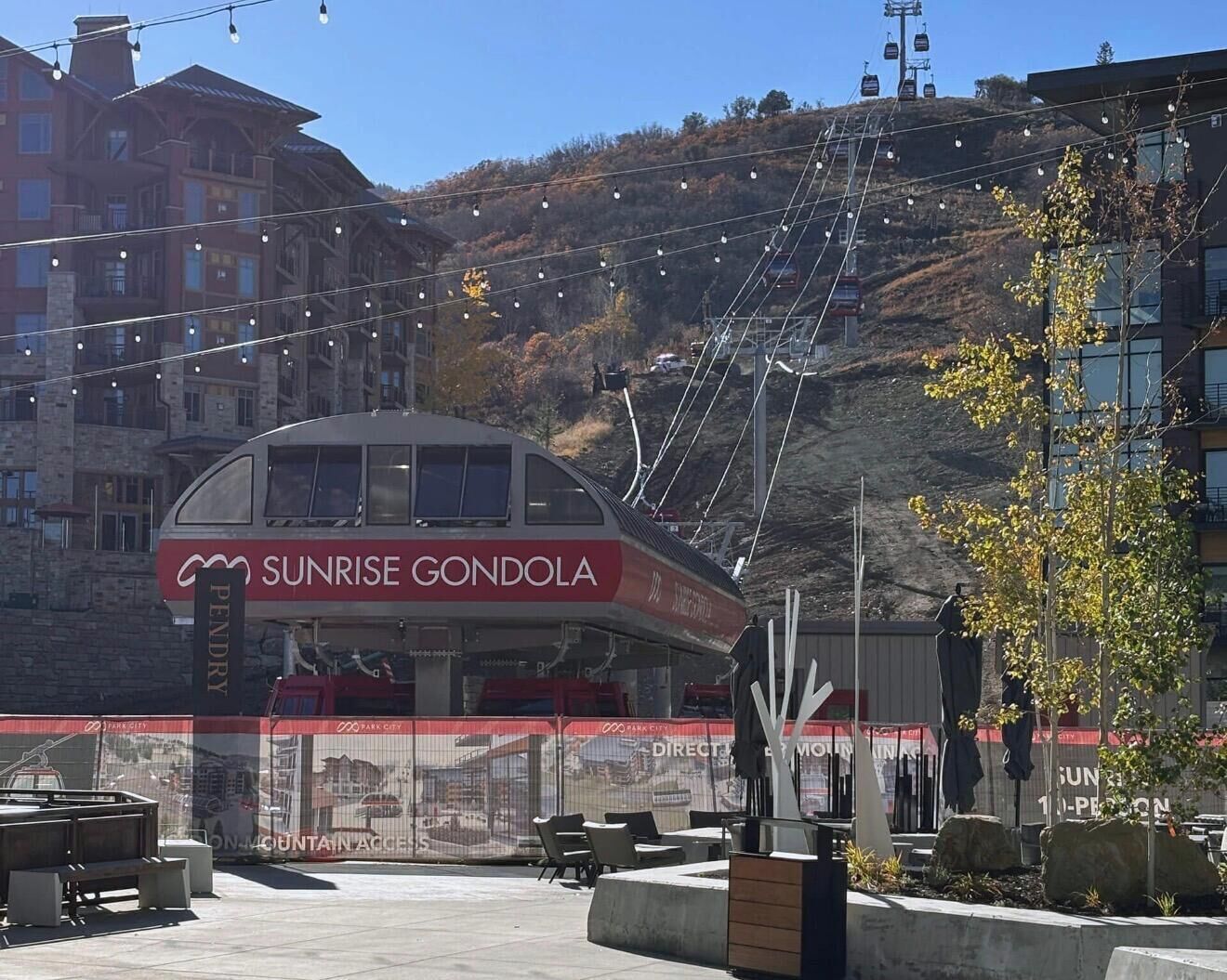 Un edificio con un letrero que dice "Sunrise Gondola" y un telesilla al fondo.