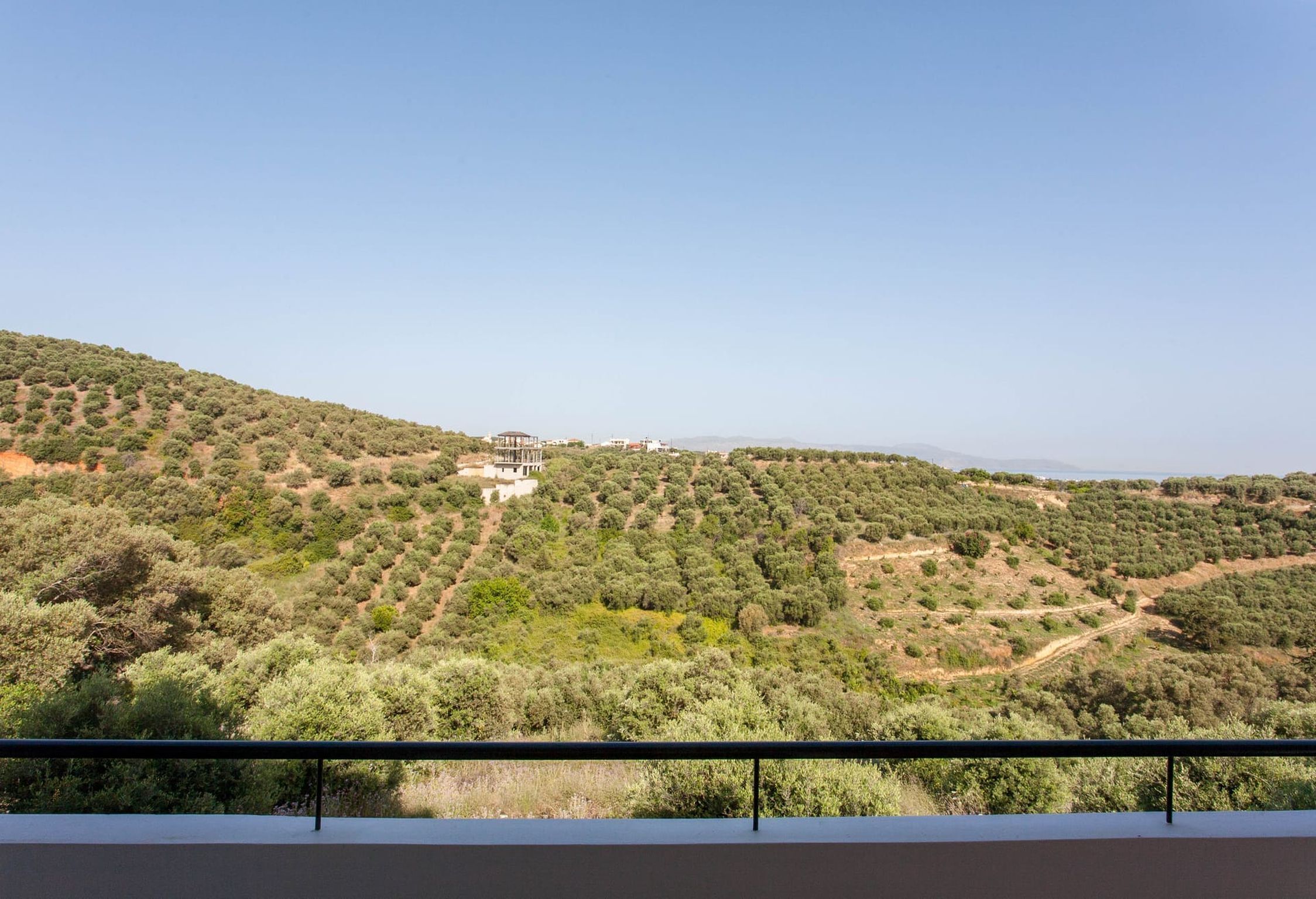 Un paisaje montañoso con un edificio rodeado de vegetación densa.
