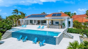 A modern house with a swimming pool, solar panels, and outdoor seating. - Perfect for Groups! 7BR Villa w/ Pool, Ocean Views (Noord)