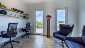 Um espaço de escritório moderno com duas cadeiras de escritório pretas, piso de madeira e vista através de amplas janelas.