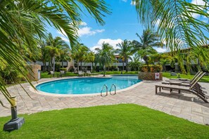 A swimming pool with lounge chairs and palm trees. - 3BR Condo w/ Patio & Pool near Eagle Beach (Noord)