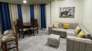 A living room with a dining table, chairs, a sofa, and an ottoman. - beautiful house in the city (San Francisco de Macorís)