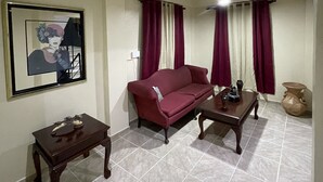 A living room with a sofa, coffee table, and a framed picture on the wall. - beautiful house in the city (San Francisco de Macorís)