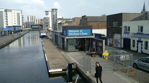 Vista al frente del agua con un letrero que dice 'Welcome to Edinburgh Quay'.