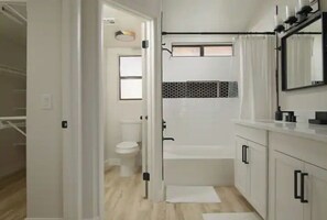Bathroom features a walk-in shower, toilet, and sink with a mirror.