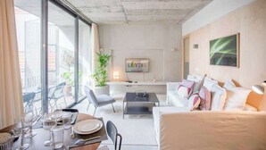 Ein modernes Wohnzimmer mit Essbereich, großen Fenstern und Blick ins Freie.