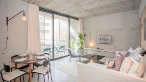 Ein modernes Wohnzimmer mit Essbereich, großen Fenstern und Blick ins Freie.