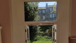 A doorway leading to a garden with a lawn and a small pond. - Very central, next to the Castle with garden (Edinburgh)