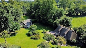 A rural property with two thatched-roof cottages surrounded by lush greenery and a well-maintained lawn. - Typical cottage and outbuilding near Honfleur and Deauville  (QUETTEVILLE)