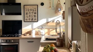 A compact kitchen with white cabinets, a gas stove, a built-in oven, and a small sink. - Typical cottage and outbuilding near Honfleur and Deauville  (QUETTEVILLE)