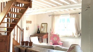 A rustic interior with a wooden staircase, a dining table, and a lamp. - Typical cottage and outbuilding near Honfleur and Deauville  (QUETTEVILLE)