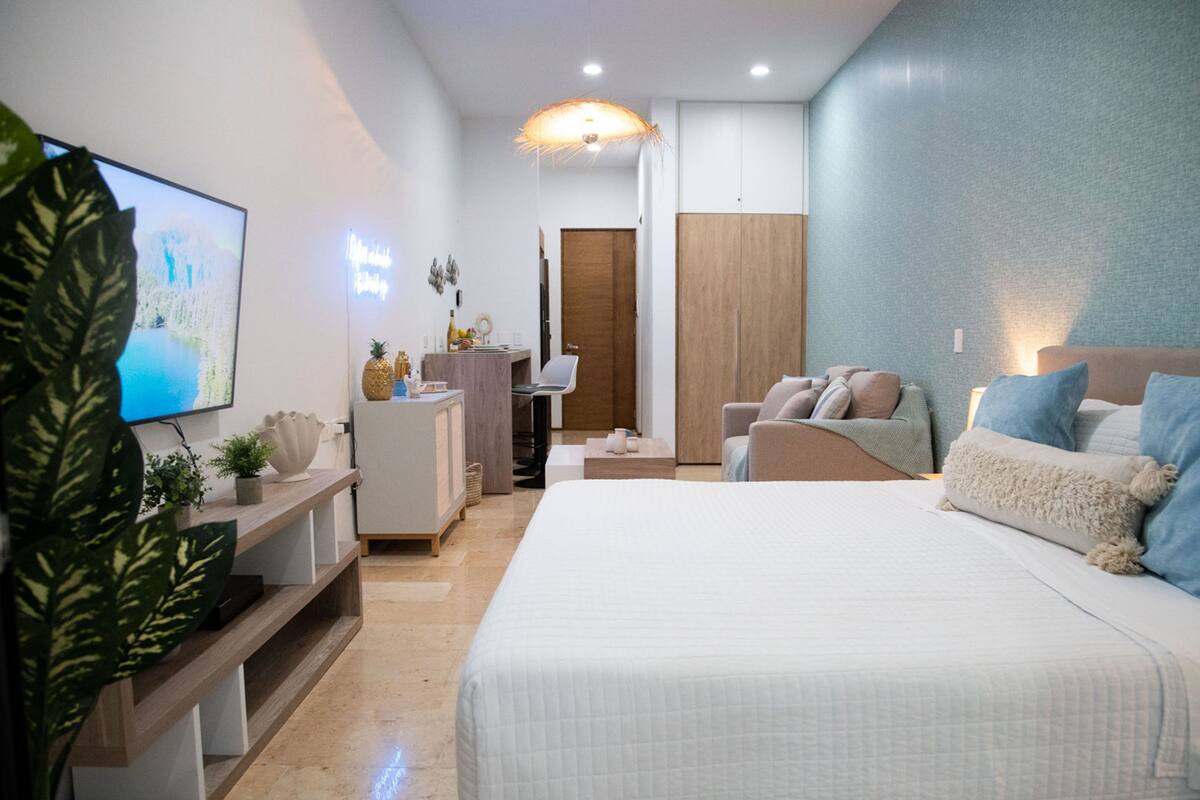 Un dormitorio moderno con una cama grande, un escritorio y un televisor.