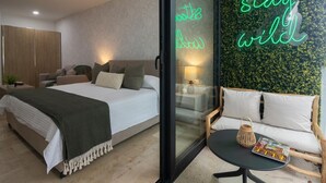 A modern bedroom with a bed, a sofa, and a neon sign. - Perfect Place (Playa del Carmen)