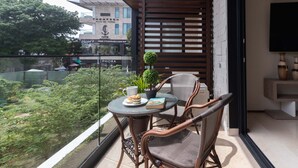 A balcony with wicker chairs, a small table with a plant, a book, and a coffee cup. - Perfect Place (Playa del Carmen)
