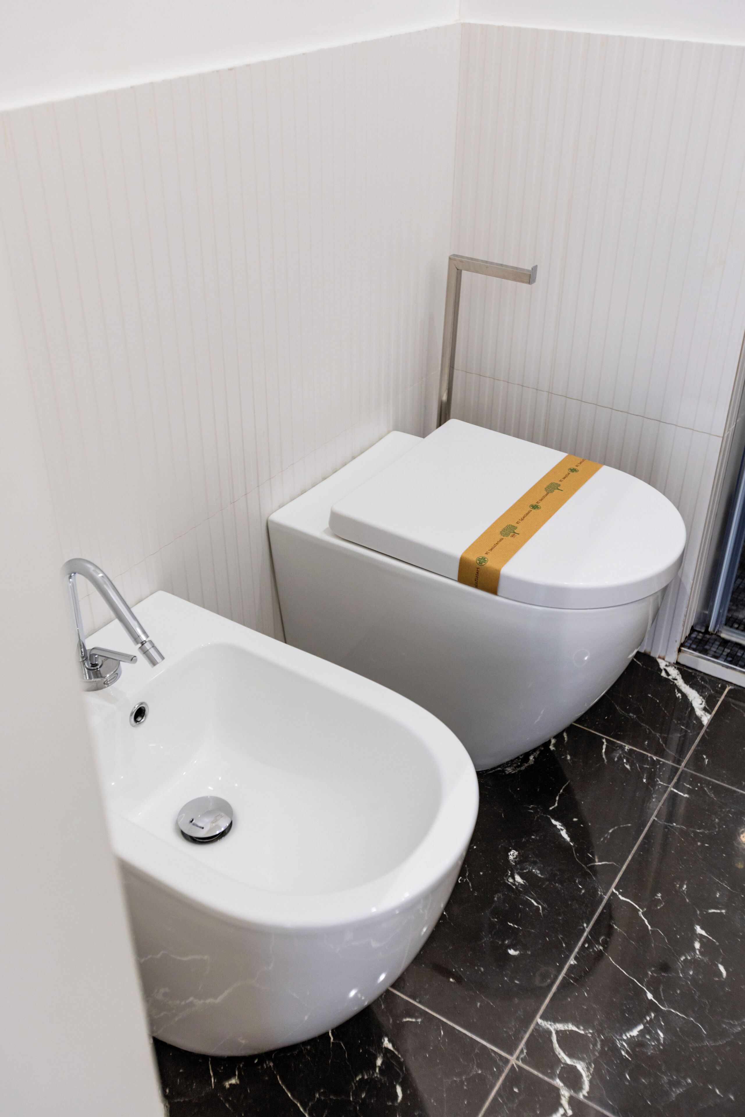 A bathroom with a white toilet, a bidet, and a sink.