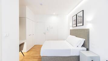 A modern bedroom with a bed, bedside table, and wardrobe.