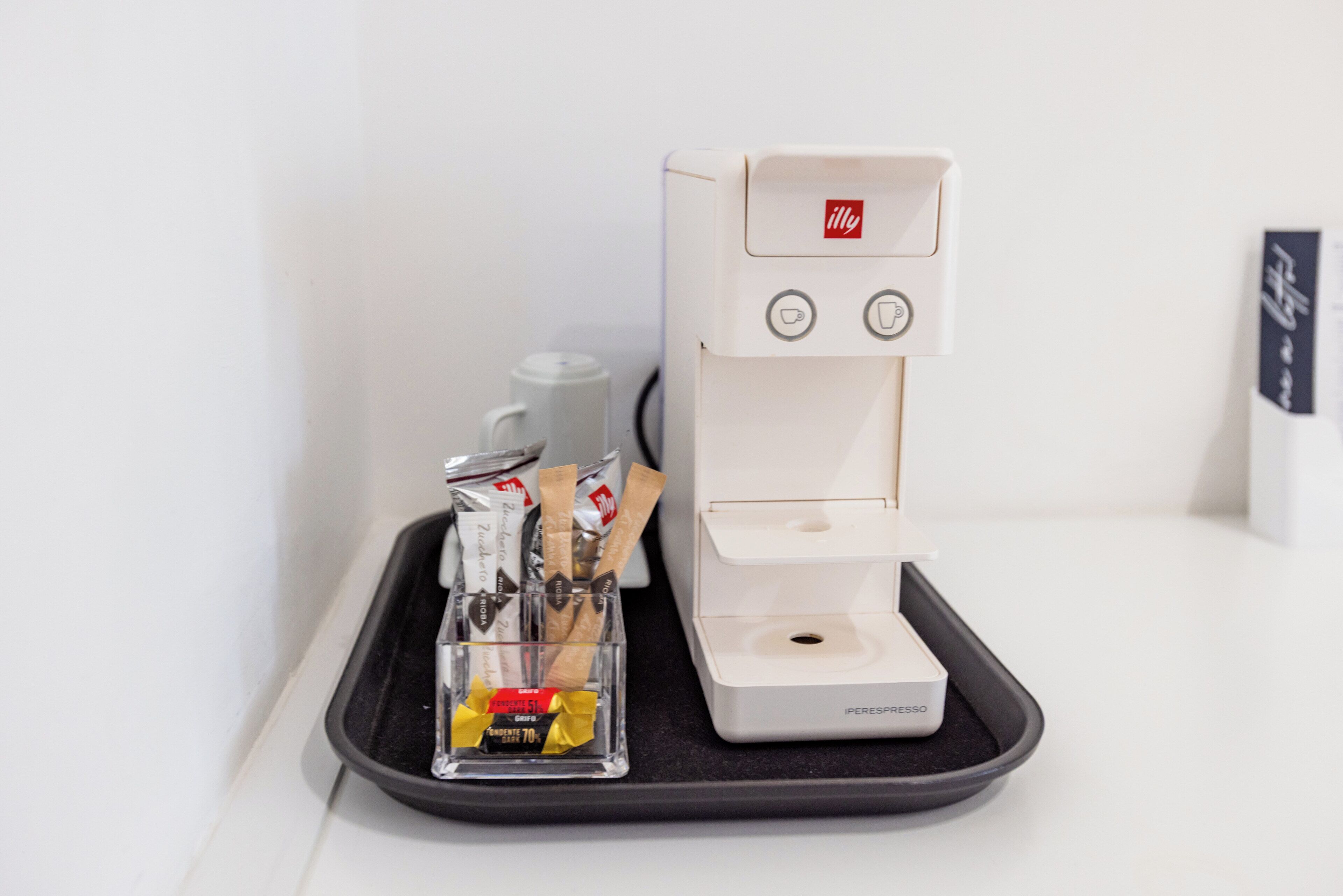 Une machine à café avec un compartiment contenant une dosette de café, une tasse et quelques en-cas.