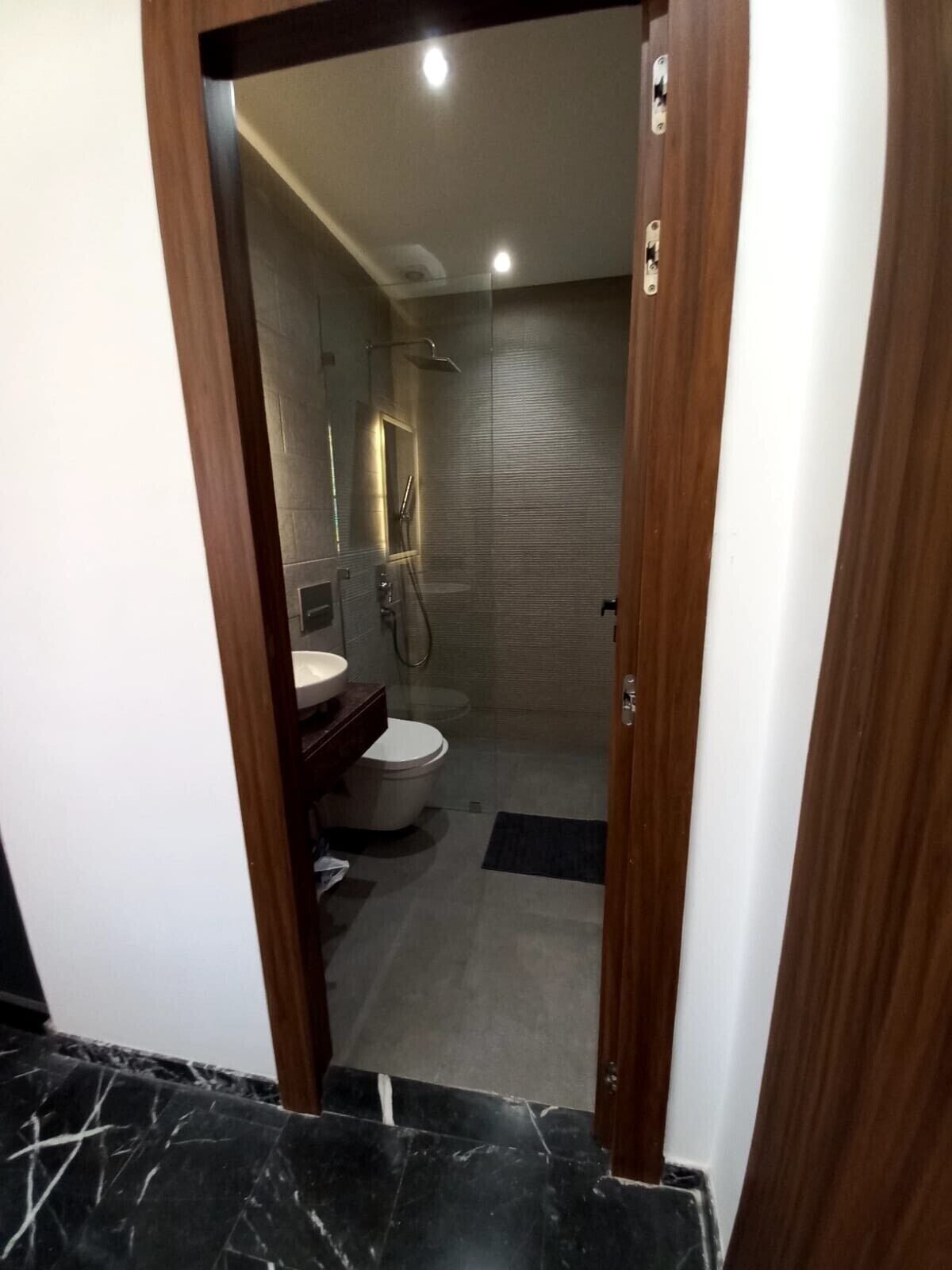 A modern bathroom with a toilet, sink, and shower.