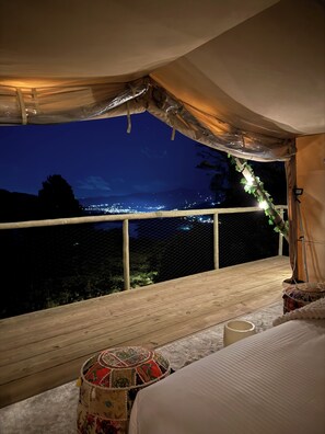 A tented room with a view of a city at night. - Sukha Resort (La Calera)