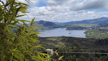 Une vue magnifique sur un lac entouré de montagnes et de verdure, sous un ciel dégagé.