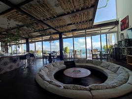Amplia sala de estar con un amplio arreglo de asientos curvos y una mesa de centro. La habitación cuenta con ventanas grandes que ofrecen vistas al exterior.