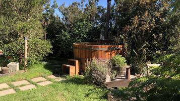 A rustic outdoor area with a wooden barrel, a chimney, and a stone pathway.