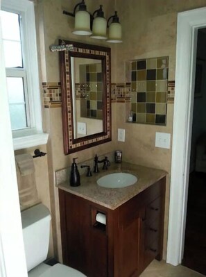 A bathroom with a vanity, sink, and mirror. - Loveday's Beach House 1 (Delray Beach)