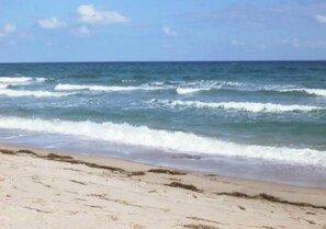 A beach with waves approaching the shore.