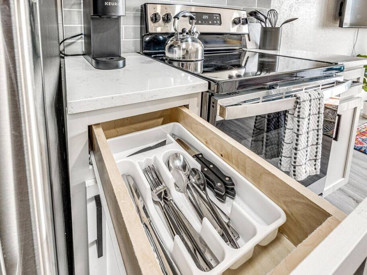 Een keuken met een lade-organizer met keukengerei.