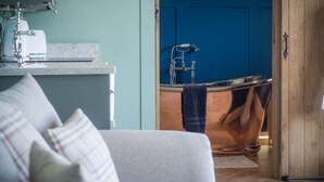 A modern bathroom with a blue door, a bathtub, and a sink.