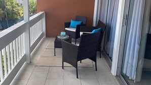 Un balcon doté de meubles en osier, d’une table et offrant une vue sur la ville.